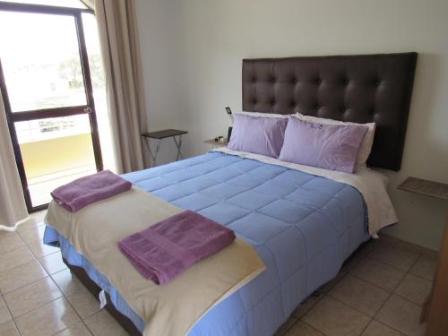 a bedroom with a large bed with purple pillows at DEL VALLE HOUSE II in Ica