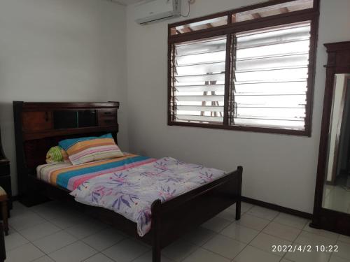 a bedroom with a bed and a window in it at Kelana 2 Nice Homestay (5 Bed Rooms) Semarang in Semarang