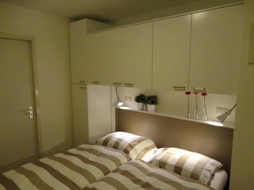 twee bedden in een kamer met gestreepte kussens bij Appartement Baken in Hollum