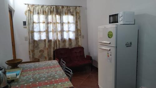 una cucina con frigorifero, tavolo e sedia di Alojamientos MiKa a Puerto Iguazú