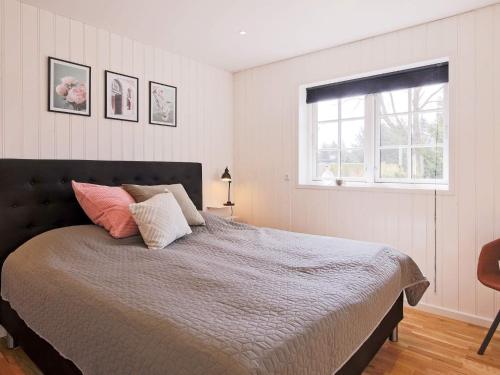 a bedroom with a large bed with a window at Modern Retreat in Marielyst - By Traum Ferienwohnungen in Marielyst