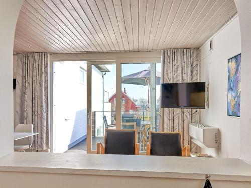 a dining room with a table and chairs and a television at 5 person holiday home in Allinge-By Traum in Allinge