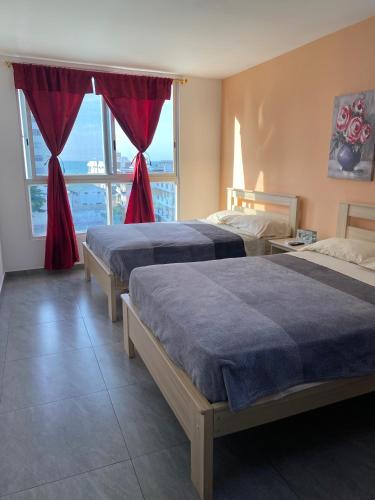 a bedroom with two beds and a large window at Kattyapartament 303 Salinas in Salinas
