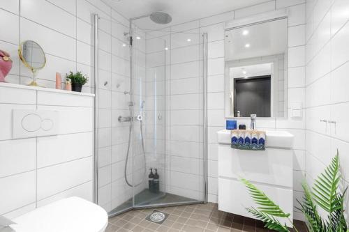 a white bathroom with a shower and a sink at Scandpoint Apartment Fornebu Near Sea front with outdoor walk! in Stabekk