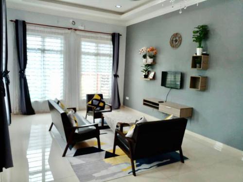 - un salon avec des chaises, une table et un piano dans l'établissement Cassa Villa Guest House Pasir Mas, à Pasir Mas