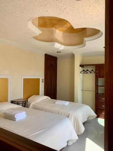a bedroom with two beds and a domed ceiling at Hotel La Condesa in Huasca de Ocampo