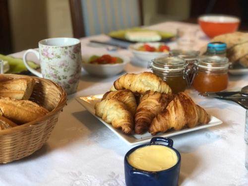 un tavolo ricoperto di piatti di prodotti da forno e un cesto di pane di la maison des ateliers a Solférino