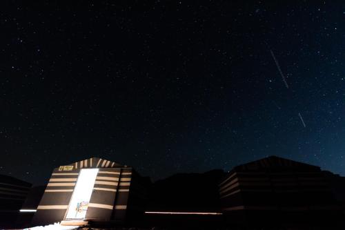 ein Gebäude in der Nacht mit Sternenhimmel in der Unterkunft Wadi Rum Meteorite camp in Wadi Rum
