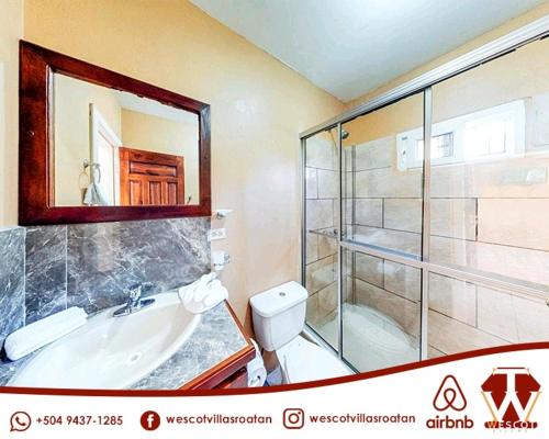 een badkamer met een douche, een wastafel en een toilet bij Wescot Villas Comfort in Roatan