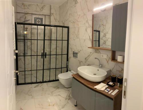 ein weißes Bad mit einem Waschbecken und einem WC in der Unterkunft شقه ارسين in Yunuseli