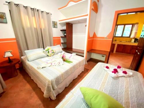 a bedroom with two beds in a room with orange walls at Villas Verdes in Sámara