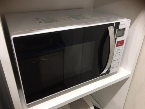 a microwave oven with its door open on a wall at Chura Gahna House Tsubogawa Naha in Naha
