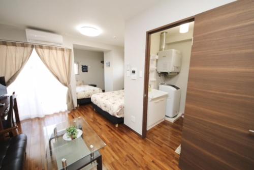 a room with a bedroom with a bed and a mirror at Chura Gahna House Tsubogawa Naha in Naha