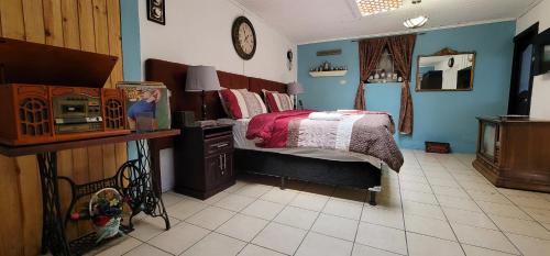 a bedroom with a bed and a microwave in it at Hotel Vintage "Casa las Flores" in Quetzaltenango