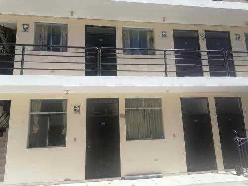a building with black doors and a balcony at Hostal Carmen in Arequipa