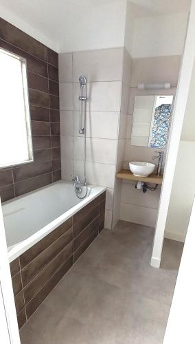 une salle de bain avec une baignoire et un lavabo dans l'établissement Histoire de Loire La Gabare, à Saumur