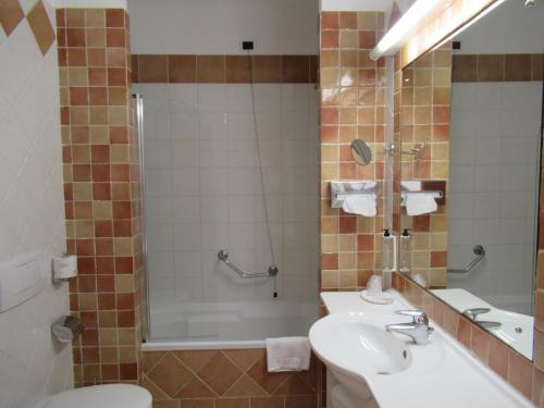 ein Bad mit einem Waschbecken, einer Dusche und einem WC in der Unterkunft TH Capoliveri - Grand Hotel Elba International in Capoliveri