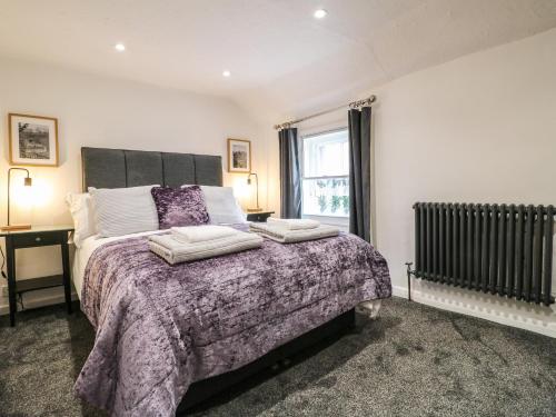 Un dormitorio con una cama grande y una ventana en The Nestling - 5 Victoria Cottages, en Bakewell