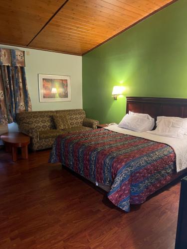ein Hotelzimmer mit einem Bett und einem Sofa in der Unterkunft Town & Country Motel in Clinton