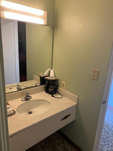 a bathroom with a sink and a mirror at Town & Country Motel in Clinton