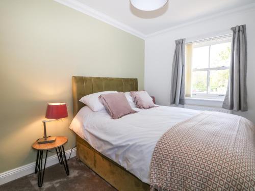 a bedroom with a bed and a window at Trinity Cottage in Christchurch