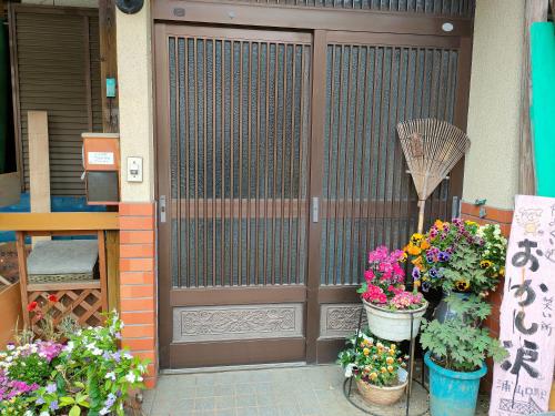 eine Holztür mit ein paar Blumen davor in der Unterkunft きっとあい楽館 in Chichibu