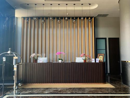 a lobby with a reception desk with flowers on it at Grand Miami Hotel in Malang