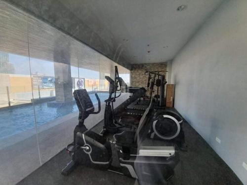 a gym with exercise bikes and a swimming pool at Sunvida Condo across SM City Cebu w/ WIFI and View in Cebu City