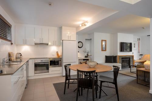 a kitchen and living room with a table and chairs at Snowgoose Apartments in Thredbo