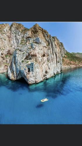 a boat in the water next to a rock formation at le mura in Iglesias