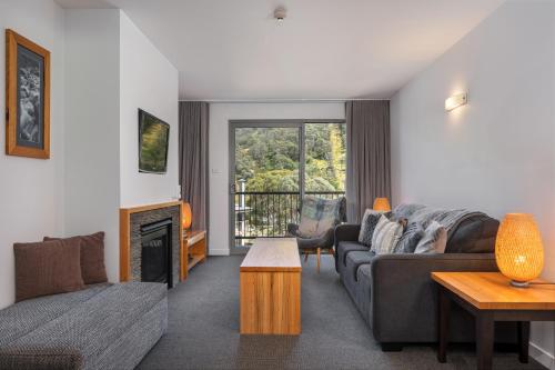a living room with a couch and a fireplace at Snowgoose Apartments in Thredbo