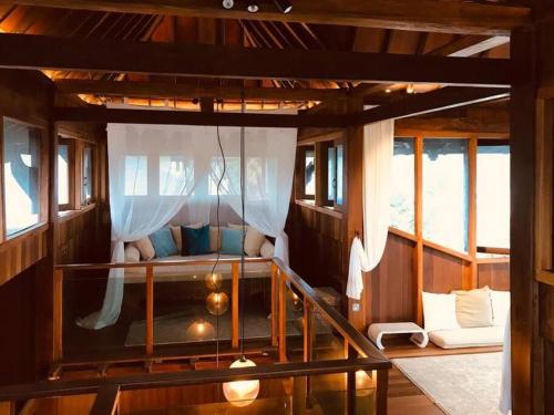 a room with a bed in a boat with windows at Grand Serene Lakeside Bali Style Villa in Cyberjaya