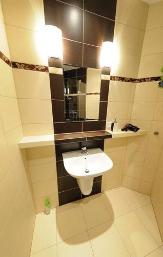 ein Bad mit einem Waschbecken und einem Spiegel in der Unterkunft Selene - Pantheon Apartments in Krakau