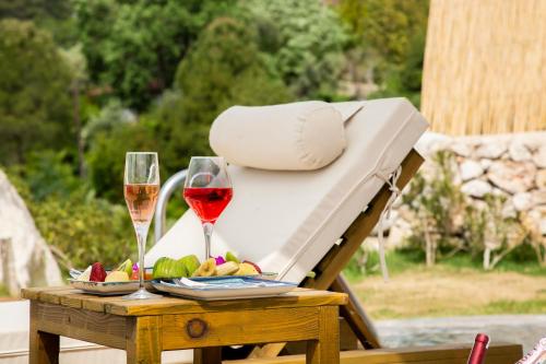 a table with two glasses of wine and fruit at Vista Del Amor Faralya in Fethiye