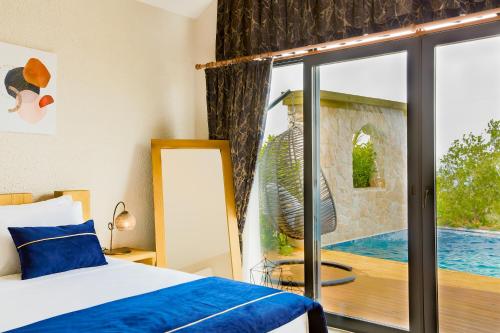 a bedroom with a bed and a view of a pool at Vista Del Amor Faralya in Fethiye