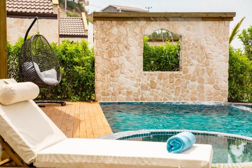 a swimming pool with a chair and a swing at Vista Del Amor Faralya in Fethiye