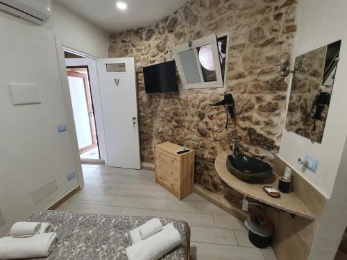 a bathroom with a sink and a tv on the wall at Il Daviduccio ibla in Ragusa