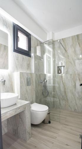 a bathroom with a toilet and a sink and a shower at Aeonian Luxury Suites Asprovalta, Adults Only & Kids 12 Plus in Asprovalta