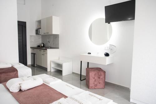 a white room with a bed and a sink at Aeonian Luxury Suites Asprovalta, Adults Only & Kids 12 Plus in Asprovalta