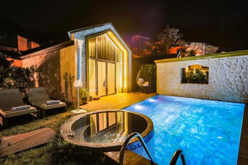 a large swimming pool in a backyard at night at Vista Del Amor Faralya in Fethiye
