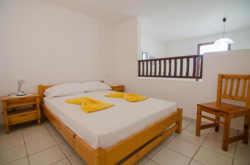 a bedroom with a bed with two yellow towels on it at Golden Sun in Ios Chora
