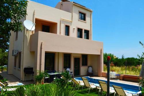 a house with a swimming pool in front of it at Belle Verte Villa Maleme in Maleme