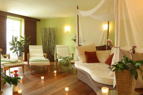 a living room with a couch and chairs and candles at Feriengut Waldblick in Sankt Oswald