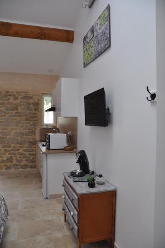 a room with a kitchen with a table and a microwave at LA MAGNANERIE in Grillon