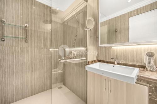 a bathroom with a sink and a glass shower at Palais by Kozystay - Thamrin in Jakarta