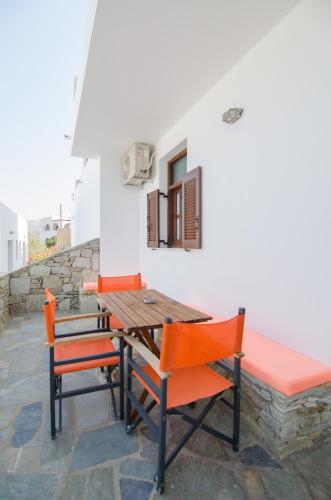 a wooden table and chairs on a patio at Golden Sun in Ios Chora
