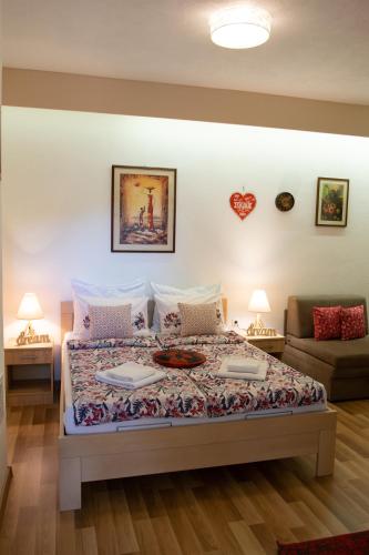 a bedroom with a bed with two tables and a couch at Villa Acapulco in Mostar