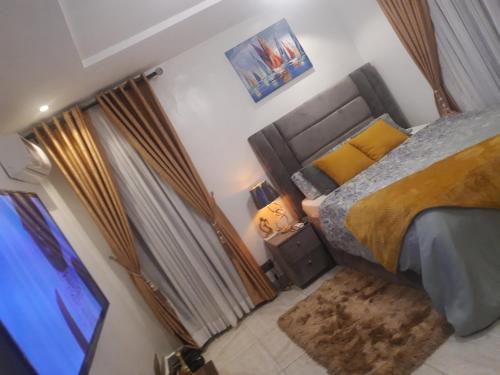 a bedroom with a bed and a television in it at HOMEDALES Freedom Way LEKKI Phase1 LAGOS in Lekki