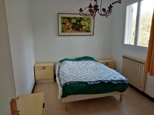 une chambre avec un lit et un tableau au mur dans l'établissement Maison tout près du port et des restaurants de Saint Aygulf, à Saint-Aygulf