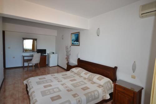 a bedroom with a bed and a desk in it at More Family Hotel in Sozopol